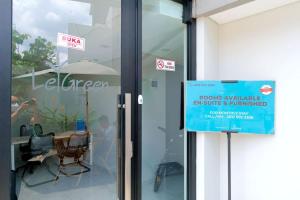 una señal frente a una puerta de cristal de un edificio en LeGreen Suite Semanggi en Yakarta