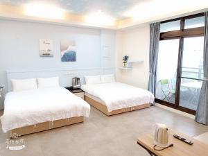 2 Betten in einem Zimmer mit Fenster in der Unterkunft 宜蘭頭城空空如也Kong Kong in Toucheng