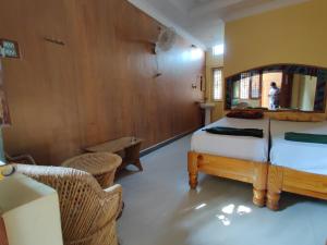 ハンピにあるAll Is Wellのベッドと鏡のある寝室