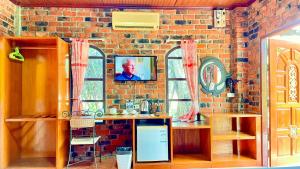 una cucina con muro di mattoni e TV a parete di Doo Dee Boutique Resort by Swiss Chalet ad Aonang Beach