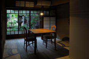 uma mesa e cadeiras num quarto com uma janela em IZUYASU Traditional Kyoto Inn serving Kyoto cuisine em Quioto