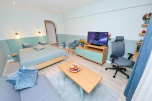 a bedroom with a bed and a desk with a television at Victoriei_Majestic in Bucharest