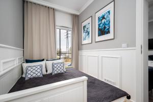 Habitación con cama con almohadas y ventana en Warsaw Apartments Prymasa Street en Varsovia