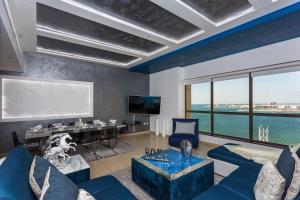 a living room with a blue couch and a table at Elan Rimal4 Suites in Dubai