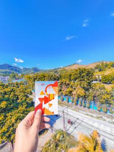 a hand holding up a sign with a view of a road at Front One Budget Abepura in Abepura