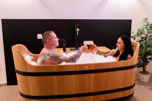 a man and a woman sitting in a hot tub at Hotel Švýcarský dům in Sněžnik