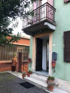 uma casa verde com uma varanda e uma porta em La Casa Verde B&B em Trivero