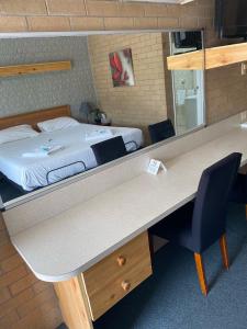 Zimmer mit einem Bett und einem Schreibtisch mit einem Schreibtisch in der Unterkunft Alexander Motor Inn in Moree