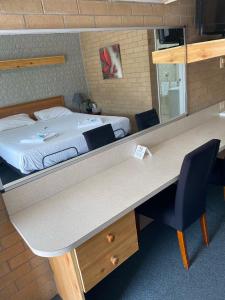 a room with a bed and a desk with a desk at Alexander Motor Inn in Moree