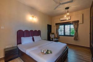 a bedroom with a large bed with a purple headboard at StayVista's Dazzle - Unwind in a Mountain-City View Villa with A Pool and Indoor Activities in Karjat