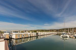 a marina with houses and boats in the water at Floating Sea House Gong in Portorož