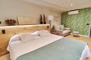 a bedroom with a large bed and a chair at Hotel Rural La Vida de Antes in Consuegra
