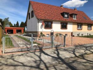 a fence in front of a house with a building at Ferienwohnungen Familie Mickley in Behrenhoff +37 photos