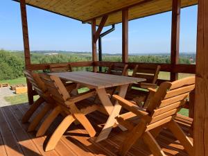 a wooden table and chairs on the deck of a cabin at Ostoja Wilka in Grochowce