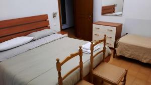 a bedroom with a bed and a dresser at Dalla Maria in Rimini
