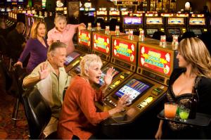 a group of people playing slot machines in a casino at Arizona Charlie's Decatur in Las Vegas