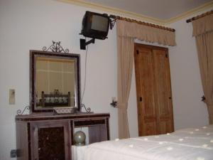 a bedroom with a bed and a mirror and a tv at Descanso Serrano in Manteigas
