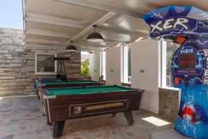 a group of pool tables in a room with a pool at LINDOS GARDENS RESORT COMPLEX in Lindos