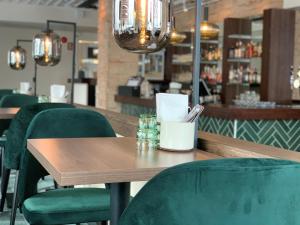 a wooden table with green chairs in a restaurant at Park Hotel Tornio in Tornio