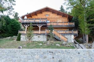 a large log house with decks on the side of it at Chalet Angel in Les Angles
