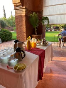 a table with a tea kettle and plates of food at LES JARDINS DE MARRAKECH in Marrakesh