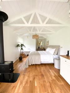 a white bedroom with a bed and a fireplace at Ragnar Glamp Koknese in Koknese