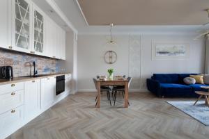 a kitchen and living room with a blue couch at Elite Apartments Granaria The View in Gdańsk