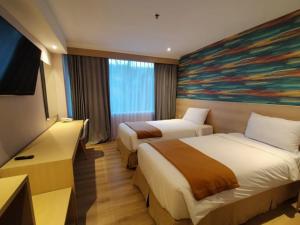a hotel room with two beds and a painting on the wall at Hotel Lereng Bromo in Pasuruan