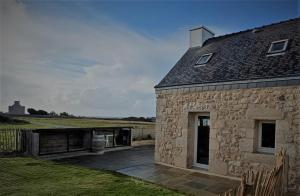 a stone house with a deck next to it at La Lanterne du Bout du Monde in Lampaul