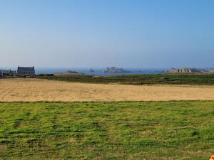 ランポールにあるLa Lanterne du Bout du Mondeの遠方の家がある草原 +3枚の写真