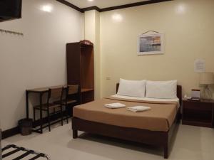 um quarto com uma cama com duas toalhas em AB Star Suites em General Santos