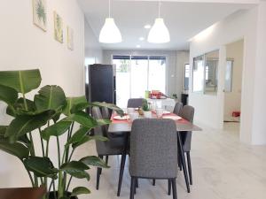 a dining room with a table and chairs and a plant at Merdeka One Homestay 8pax 4Rooms in Sibu