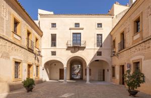 塞维利亚Casa de la Moneda Residences Sevilla的带阳台的古老建筑中的小巷