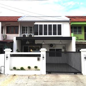 a white house with a gate and a fence at Merdeka One Homestay 8pax 4Rooms in Sibu