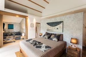 a bedroom with a large bed and a living room at Khwan Beach Resort - Luxury Glamping and Pool Villas Samui - Adults Only - SHA Extra Plus in Mae Nam