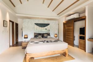 a bedroom with a large bed and a television at Khwan Beach Resort - Luxury Glamping and Pool Villas Samui - Adults Only - SHA Extra Plus in Mae Nam