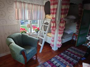 salon z krzesłem i łóżkiem piętrowym w obiekcie Soldattorpet Sands w mieście Leksand
