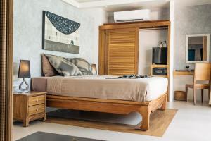a bedroom with a bed with a wooden headboard at Khwan Beach Resort - Luxury Glamping and Pool Villas Samui - Adults Only - SHA Extra Plus in Mae Nam