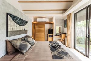 a bedroom with a large bed with a large window at Khwan Beach Resort - Luxury Glamping and Pool Villas Samui - Adults Only - SHA Extra Plus in Mae Nam