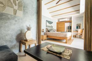 a bedroom with a bed and a table in a room at Khwan Beach Resort - Luxury Glamping and Pool Villas Samui - Adults Only - SHA Extra Plus in Mae Nam