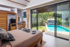a bedroom with a bed and a swimming pool at Khwan Beach Resort - Luxury Glamping and Pool Villas Samui - Adults Only - SHA Extra Plus in Mae Nam