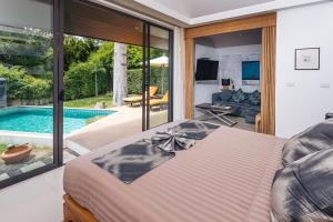 a bedroom with a bed and a swimming pool at Khwan Beach Resort - Luxury Glamping and Pool Villas Samui - Adults Only - SHA Extra Plus in Mae Nam