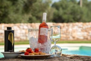 a bottle of wine and a plate of food and a glass at Masseria Borgo Santuri in Ostuni