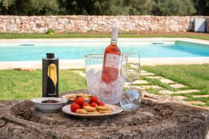 a table with a bottle of wine and a plate of food at Masseria Borgo Santuri in Ostuni