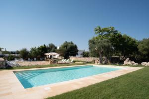 a swimming pool in the middle of a yard at Masseria Borgo Santuri in Ostuni