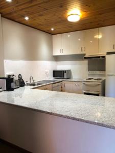 a kitchen with white cabinets and a counter top at Kingston Pines in Kingston 