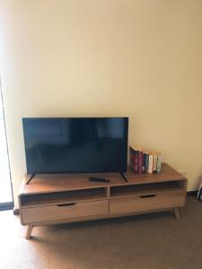 a flat screen tv sitting on top of a wooden entertainment center at Kingston Pines in Kingston 