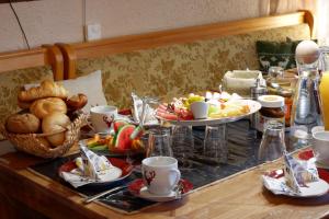 a table topped with plates of food and coffee cups at Frühstückspension Mayer-Schiller in Bernried