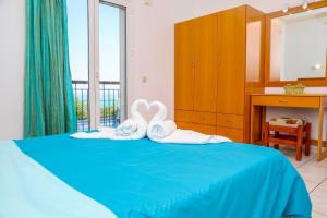 a bedroom with a blue bed with towels on it at VILLA MITZELOS in Skiathos