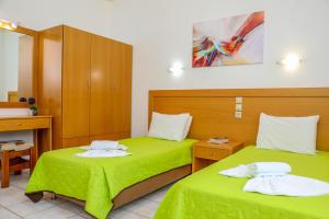 - 2 lits dans une chambre avec des draps verts dans l'établissement VILLA MITZELOS, à Skiathos Chora